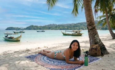 A girl laying on a beach mat in Beras Basah Island Island hopping Langkawi